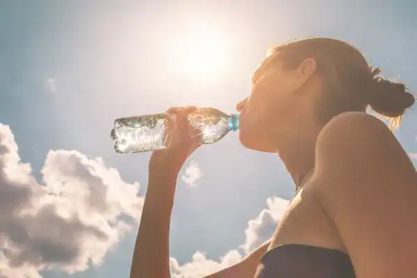 Hydration: The Secret Ingredient for a Toned Stomach and Enhanced Fitness 3 Image of woman drinking water to hydrate Bury St Edmunds after run.